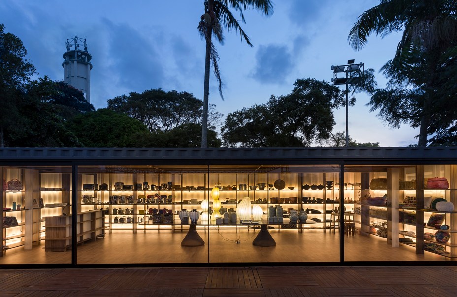 Loja CASA COR - Gustavo Calazans. Dentro do contêiner, 200 peças diferentes em madeira foram encaixadas nas paredes e no teto. O desenho dos nichos é ressaltado pela iluminação com fitas de LED, que também valoriza as criações de designers e artesãos brasileiros