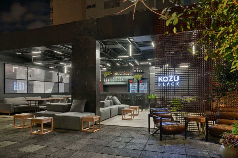 Kozu Black – André Lenza. O bar e restaurante contemporâneo de 80 m² traz a proposta de um espaço sem portas, com mesas que avançam sobre a praça central. Uma referência à cultura goiana do bar na calçada. O bar central foi revestido em mármore negresco, e as paredes laterais em madeira ebanizada nero. Na fachada, um imenso muxarabi forma uma imensa trama - por onde a luz solar entra durante o dia, e por onde a luz do bar sai a noite.