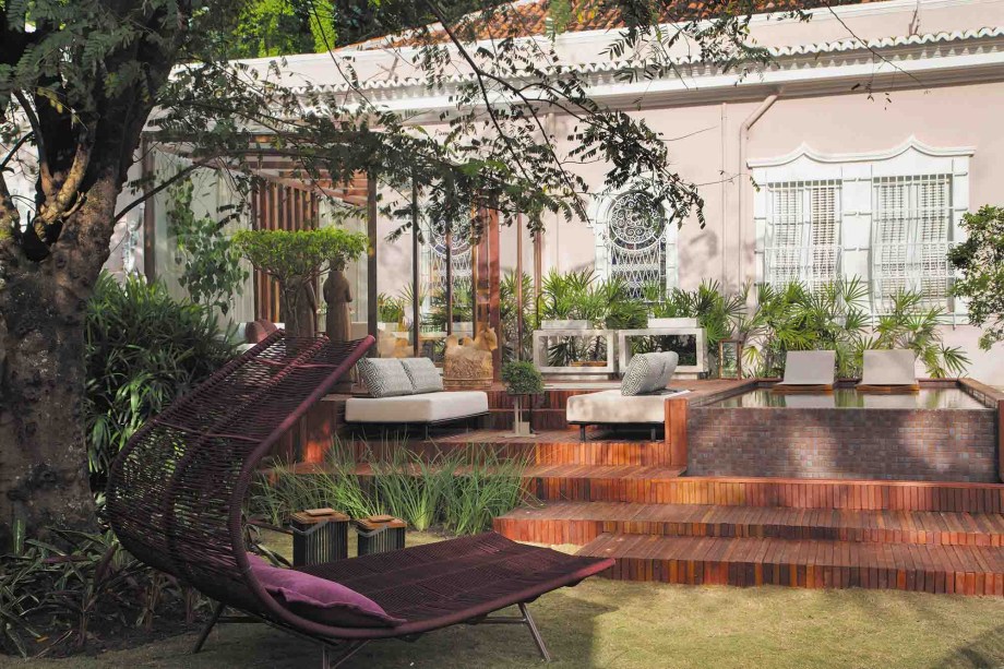 Terraço Ametista - Juliana da Mata Arquitetura. Uma caixa de vidro e madeira se integra à natureza circundante e compõe um espaço de terraço com estar, deck, piscina, gourmet e jardim, totalizando 150m2. As nuances da pedra ametista foram o ponto de partida, com o tom da piscina inspirado em um rio. O acolhimento que marca os projetos da arquiteta pode ser observado no mix de móveis de design e peças de arte popular, tornando o ambiente um convite ao relaxamento.