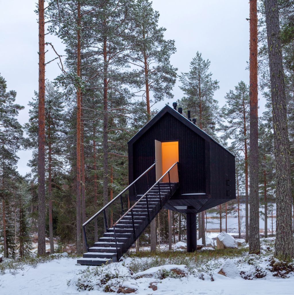 Cabana de cor preta assinada pelo Studio Puisto que elevou-a em uma única coluna. Localizado no Parque Nacional Salamajärvi, na Finlândia.