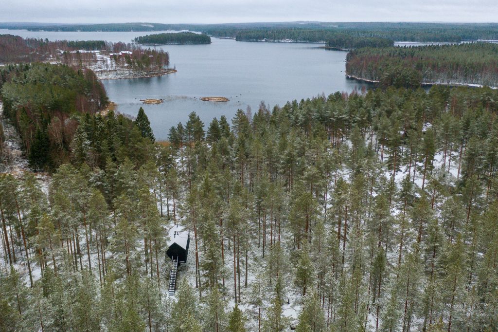 Cabana de cor preta assinada pelo Studio Puisto que elevou-a em uma única coluna. Localizado no Parque Nacional Salamajärvi, na Finlândia.