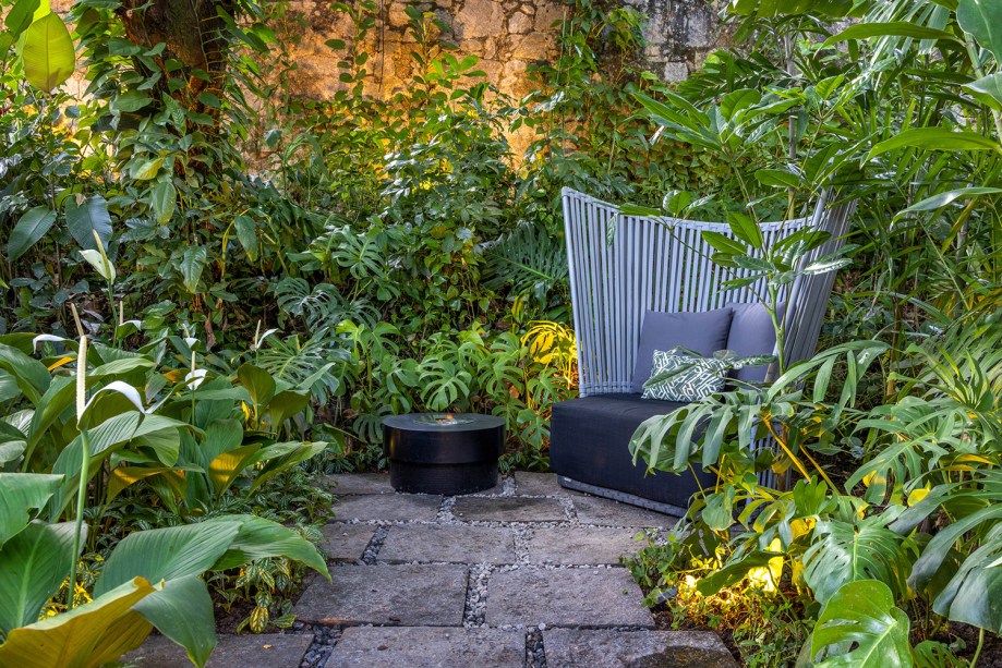 Ana Veras - Jardim do Pavilhão 22. Ao lado da piscina, a mata se torna ainda mais exuberante e colorida com a interferência paisagística. O local, onde aflora uma nascente, teve o caminho para o olho d’água aberto, convidando o visitante a viver essa experiência sensorial. Novas espécies, que atraem a fauna local (beija-flores, tucanos, saguis), foram incorporadas criando um jardim tropical de formas livres que abraça o Pavilhão 22 e traz em sua entrada duas esculturas vivas de bromélias, uma releitura dos totens de Burle Marx.