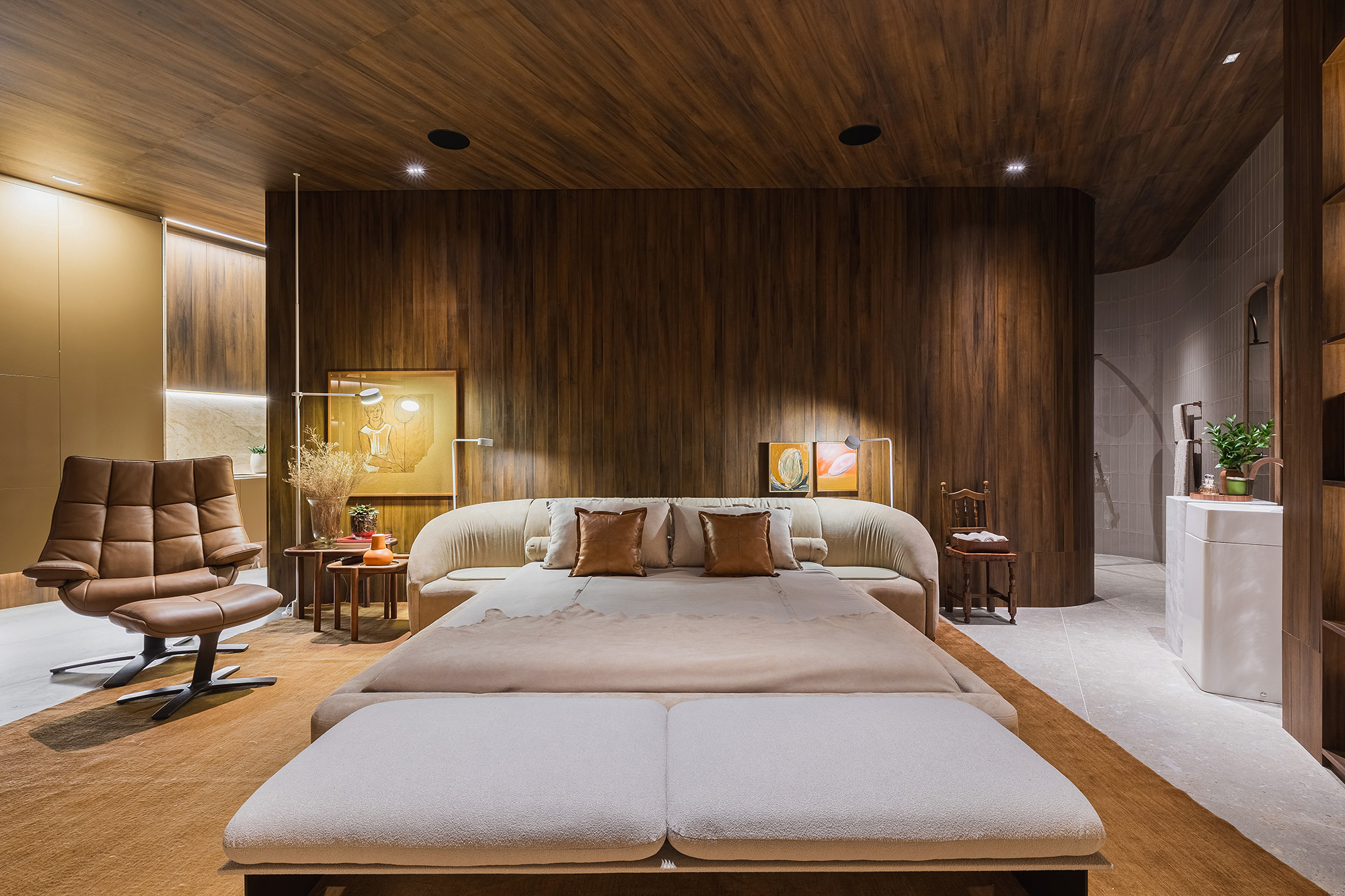 Marcelo Lopes - Loft Cosmopolita. Projeto da CASACOR Paran&aacute; 2023. Na foto, quarto com parede e teto de madeira, poltrona e cama com cabeceira estofada.